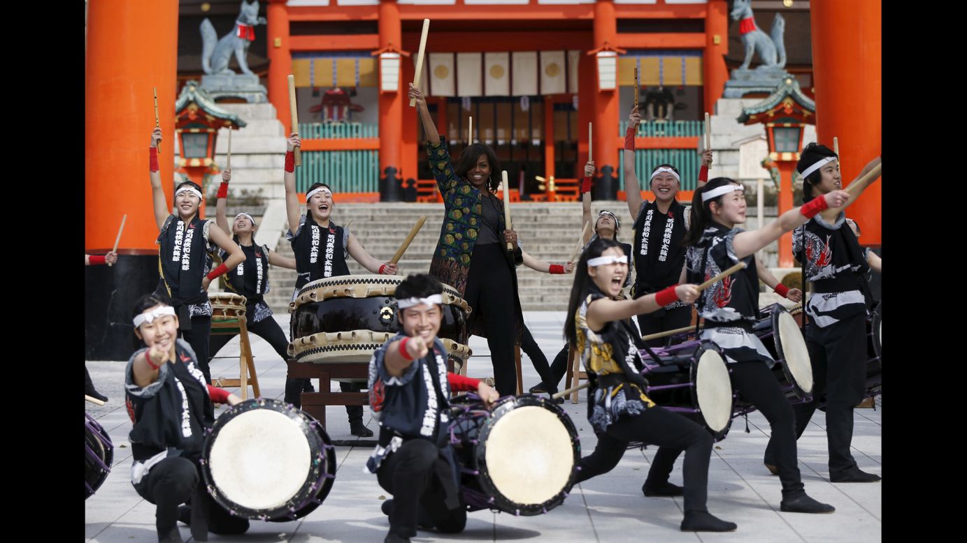 Michelle Obama, the first lady of the United States, beats a traditional taiko drum with high school students as she visits the Fushimi Inari Taisha shrine in Kyoto, Japan, on Friday, March 20.