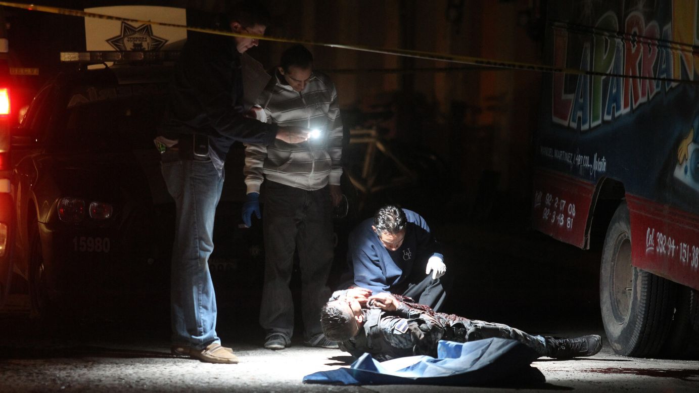 Forensic experts collect information at the scene in Jalisco, Mexico, where 10 people died in a confrontation between members of the Mexican federal police and organized crime members on Friday, March 30. Five police officers, three suspects and two civilians were killed during an attack against some members of the federal police, reports said.