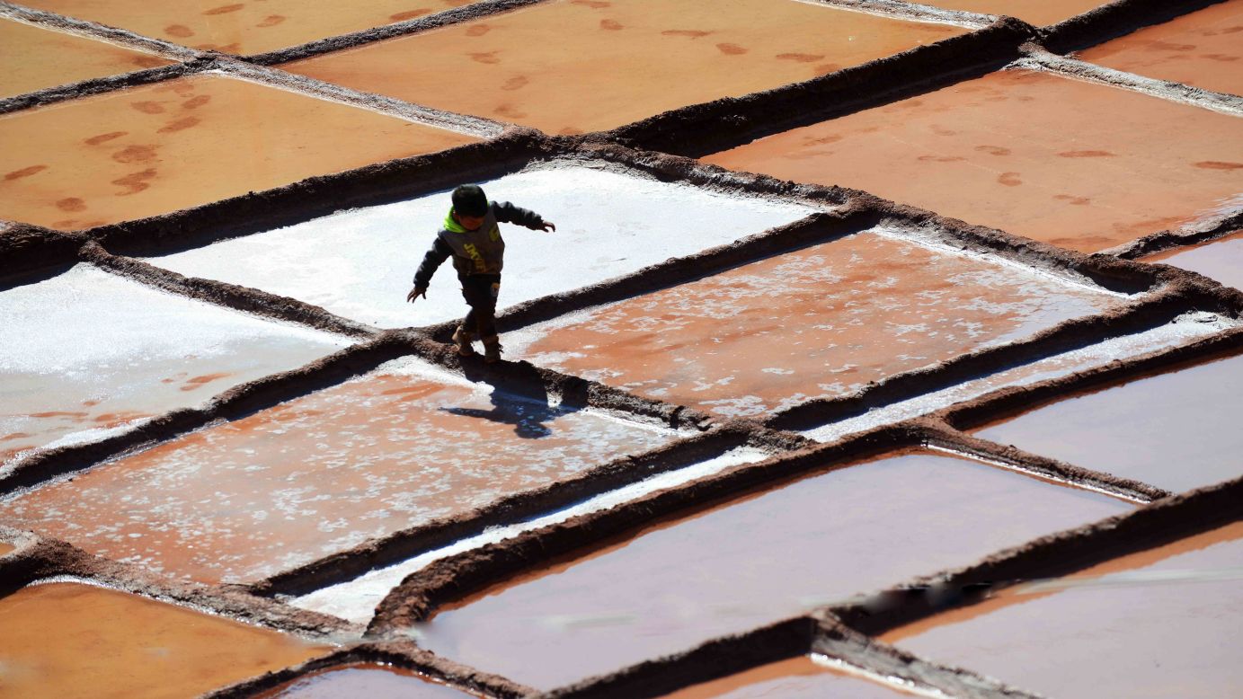 A boy plays on salt pans in Markam County, Tibet, on Saturday, March 21.