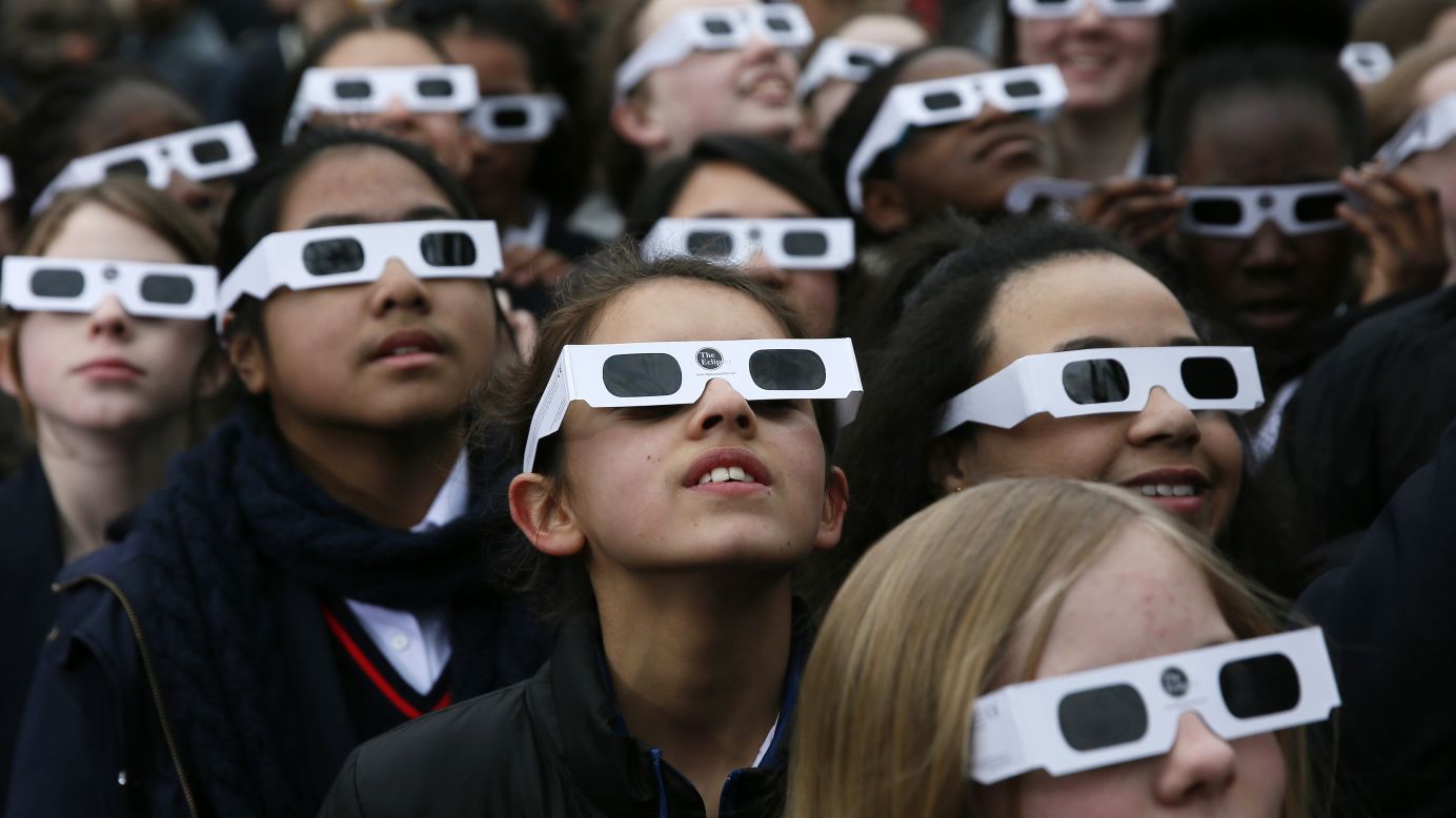 Schoolchildren wear protective glasses as they watch for a partial solar eclipse Friday, March 20, at the Royal Observatory in London.