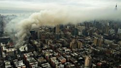 In this photo provided by the NYPD Special Ops, smoke rises from the scene of a large fire and a partial building collapse in the East Village neighborhood of New York on Thursday, March 26, 2015. Orange flames and black smoke are billowing from the facade and roof of the building near several New York University buildings. (AP Photo/NYPD Special Ops)