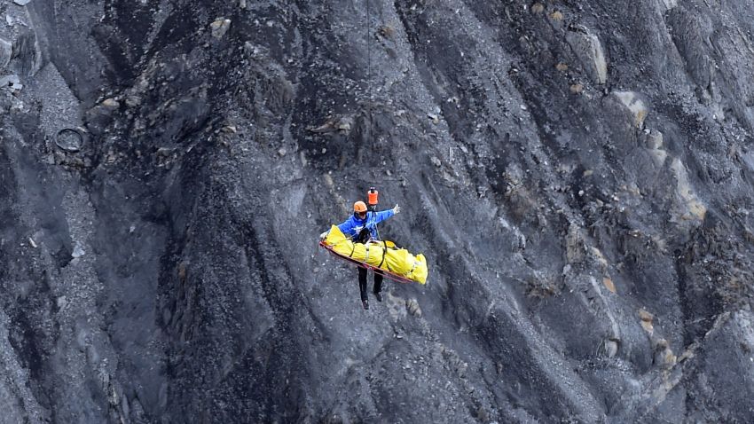 A rescue worker is lifted by helicopter from the crash site in the French Alps on March 26.