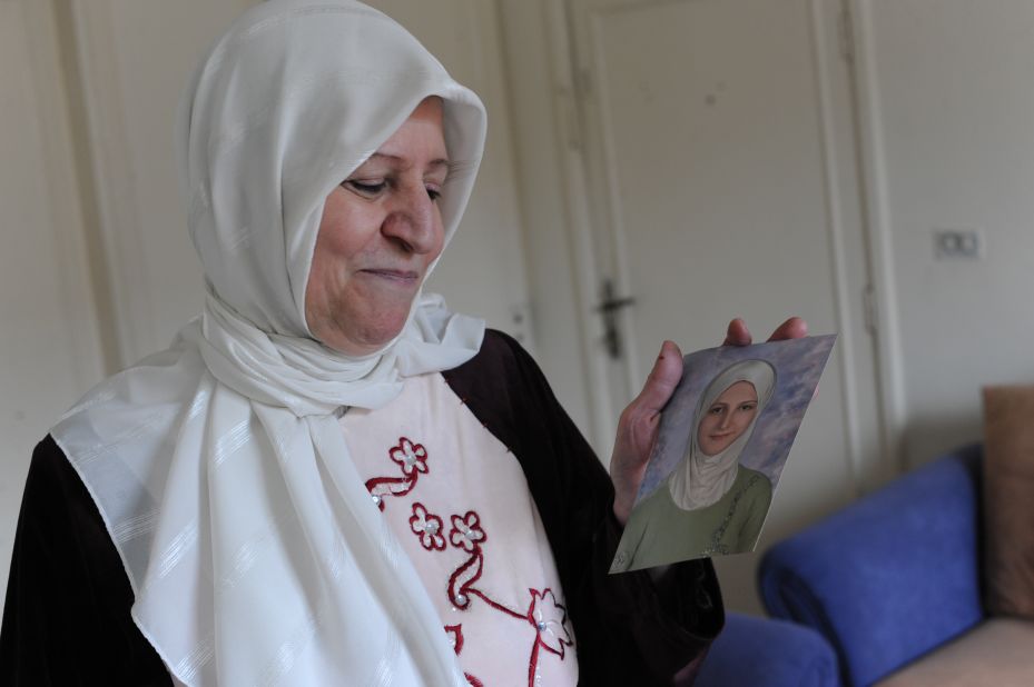 Hiba's mother, Hanan, looks at a photograph of her daughter the year she graduated from high school.  Hiba was just a couple of classes away from graduating from university when the family was forced to leave their home.