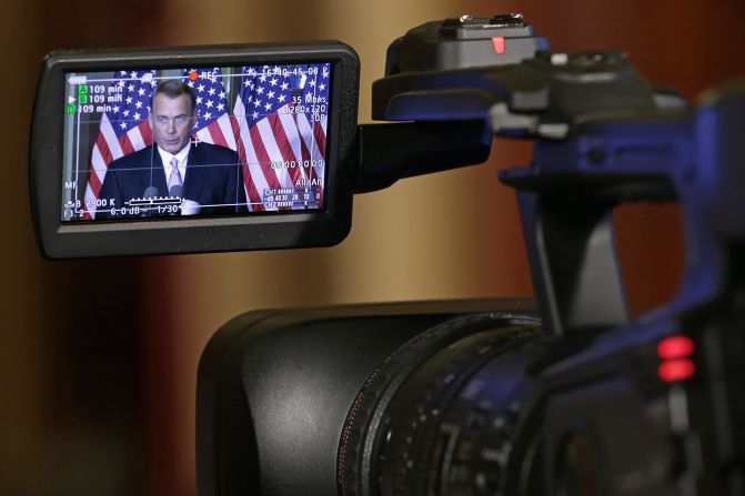 The image of the Speaker of the House John Boehner (R-OH) is displayed in a monitor of a camera as he talks with reporters in his office in the Capitol in November 2014 in Washington. 