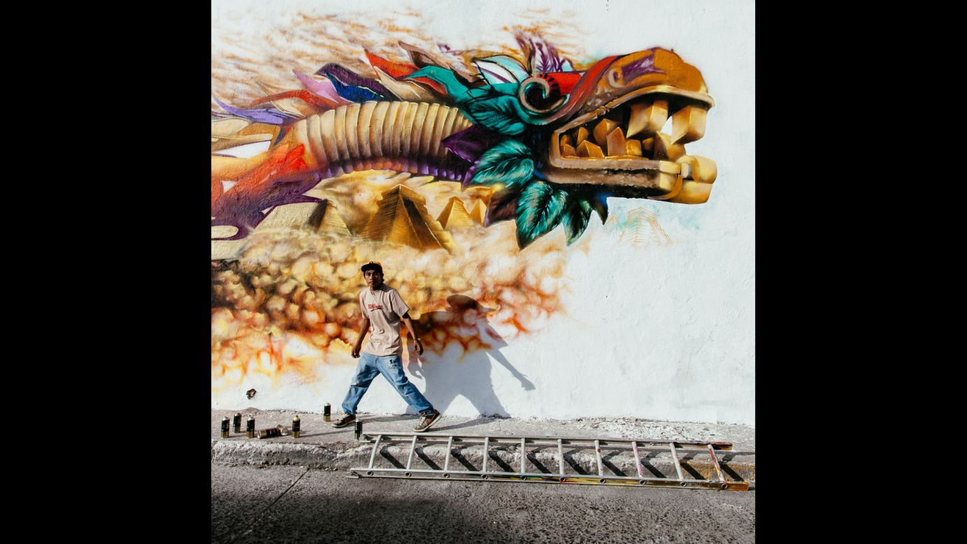 <strong>"Quetzalcoatl" by Hector Munoz Huerta</strong><br />Photographer's description: I have been snapping pictures of street performers for a couple of years. On January 31 last year I was heading downtown with my family as I found these graffiti artists working on a large mural, which I have spotted a few days before (in Queretaro, Mexico). I asked my wife to wait for five minutes and I started shooting. These boys are very talented and have been replacing ugly tag-patched walls with murals in the surroundings of the San Gregorio neighborhood for some years. This picture is my favorite image of 2014.