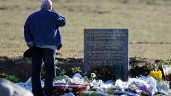 A man stands on March 29 2015 in front of a commemorative headstone in Seyne-les-Alpes, the closest accessible site to where a Germanwings Airbus A320 crashed on March 24 in the French Alps, killing all 150 people on board.

