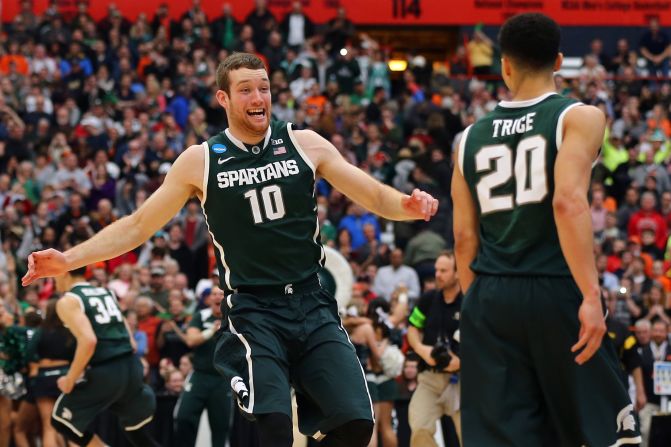 Matt Costello (10) and Travis Trice (20) of the Michigan State Spartans celebrate defeating the Louisville Cardinals 76 to 70 in overtime of the East Regional Final of the 2015 NCAA Men's Basketball Tournament at Carrier Dome on March 29, 2015 in Syracuse, New York.