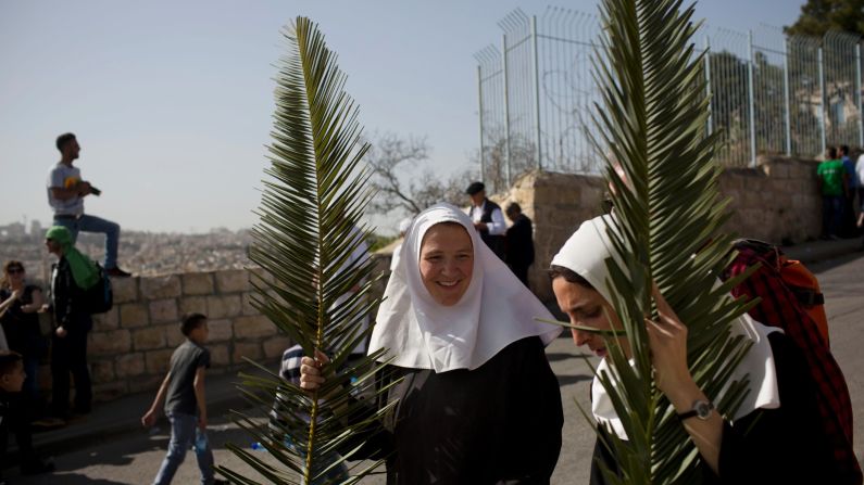 Nuns hold palm fronds during a Palm Sunday procession on the Mount of Olives, overlooking Jerusalem's Old City on March 29.