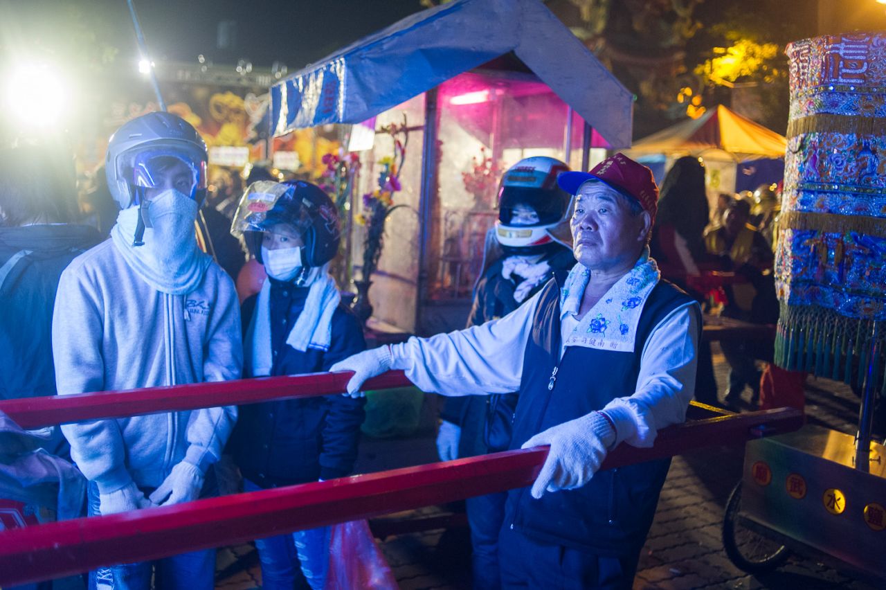A bearer for a sedan chair carrying a statue of Guan Gong, Chinese God of War. Legend has it that Guan Gong demanded that fireworks be released in exchange for protecting the town from cholera and plague. 