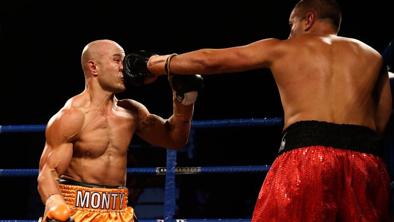 Monty Bethan, left, eats a punch from Adam Hollioake during a Super 8 boxing event Saturday, March 28, in Christchurch, New Zealand. Bethan won the bout with a fourth-round TKO.