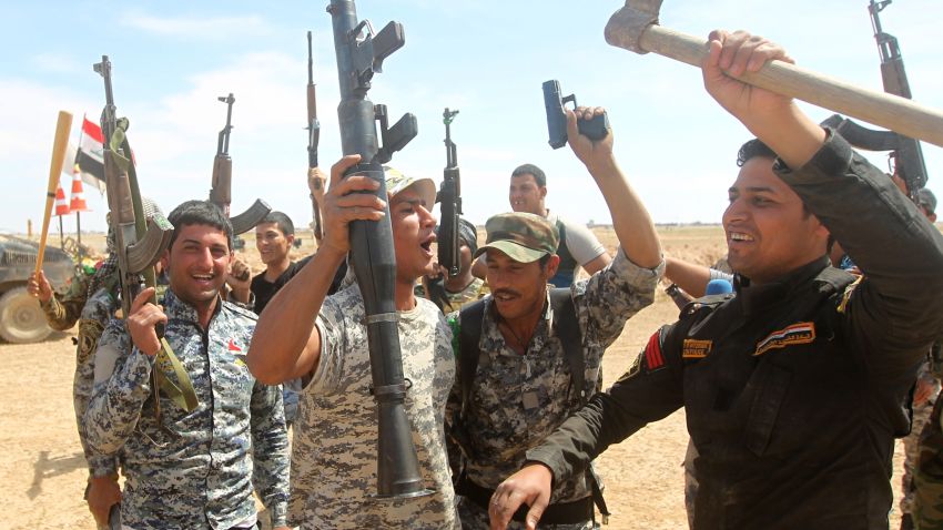 Iraqi government forces raise their weapons as they hold a position on the western outskirts of Tikrit, on March 27, 2015, during a military operation to retake the city from Islamic State group jihadists. Iraqi government forces revived a stalled ground operation to retake Tikrit on March 26, 2015, following US-led air strikes that paved the way but left the anti-jihadist camp deeply divided. AFP PHOTO / AHMAD AL-RUBAYE (Photo credit should read AHMAD AL-RUBAYE/AFP/Getty Images)