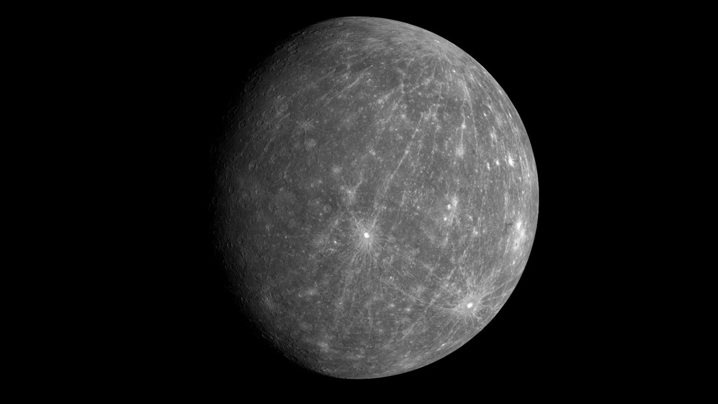 Carbon from tiny meteorites has gradually darkened Mercury's surface, researchers say.