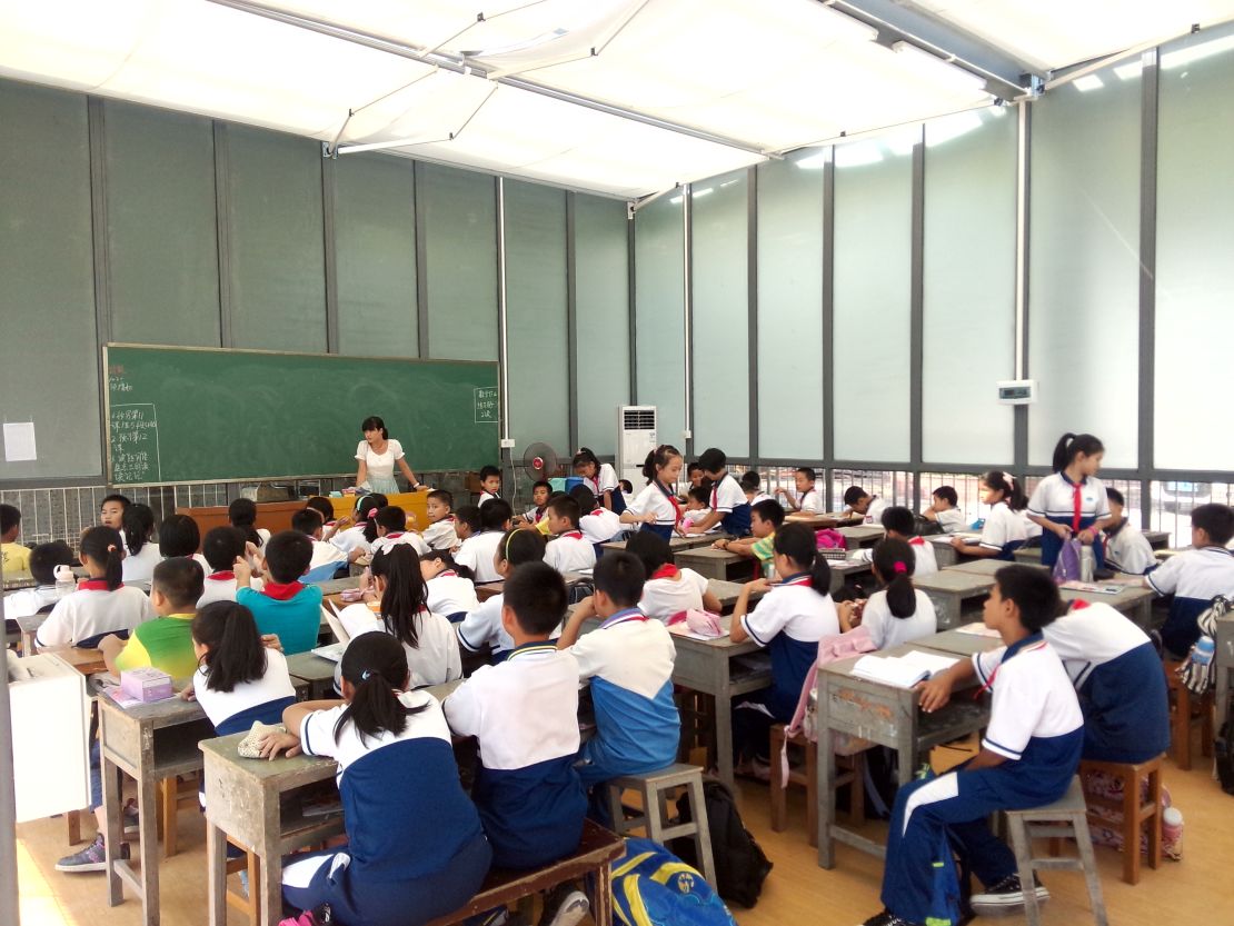 Students sit in an open glasses classroom in China for their lessons.  