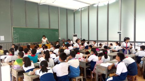 Students sit in an open glasses classroom in China for their lessons.  