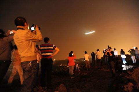 MARCH 31 - CHONGQING, CHINA: People take photos of the solar-powered aircraft Solar Impulse 2 at Chongqing Jiangbei International Airport. The aircraft, the first to be completely sustained by the sun's rays, took off from Mandalay, Myanmar's second biggest city, early Monday. It is the fifth flight of a landmark journey to circumnavigate the globe.