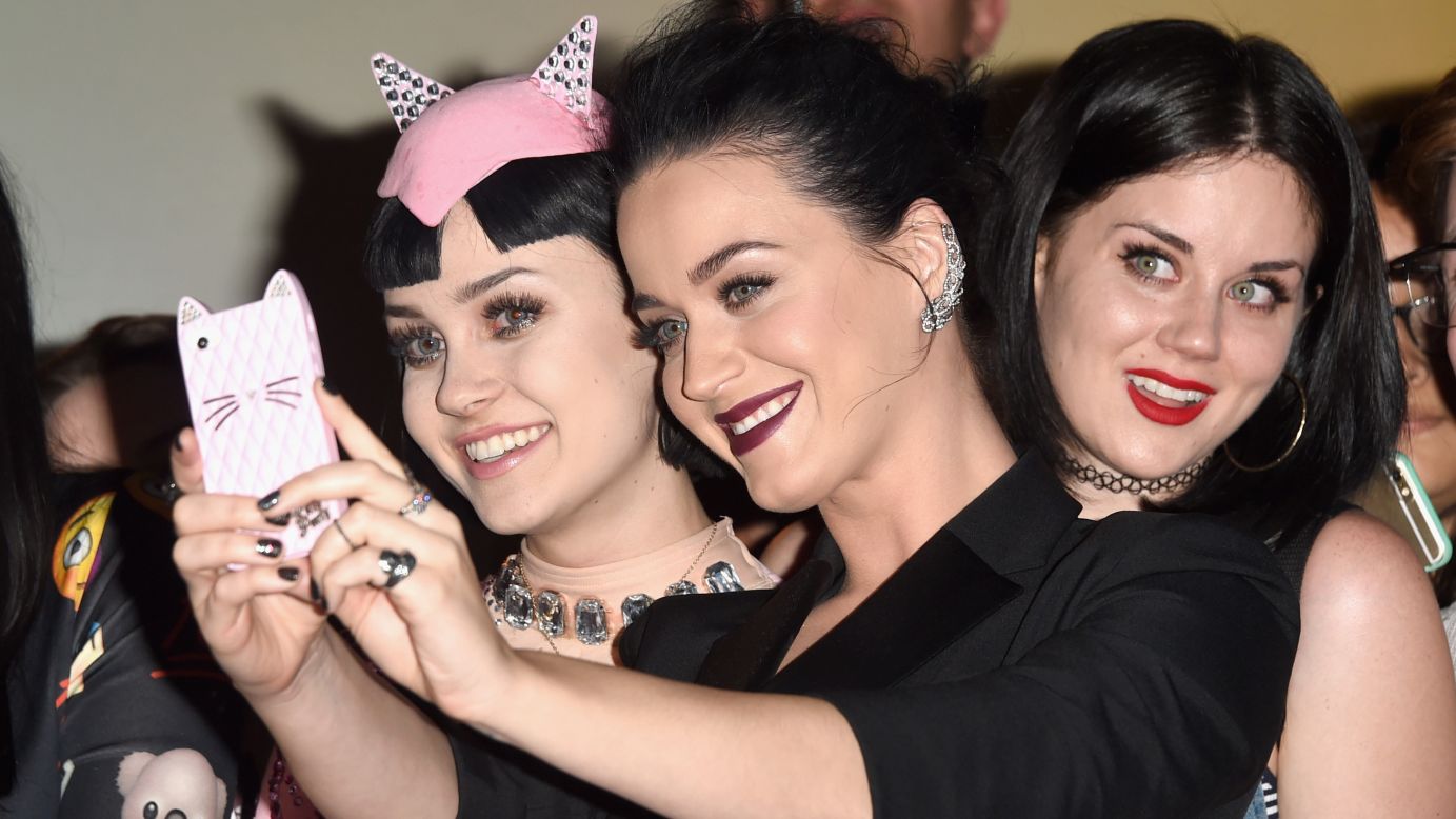 Singer Katy Perry, center, takes a selfie with lookalike fans on Thursday, March 26, at a Los Angeles screening of her concert video "Katy Perry: The Prismatic World Tour."