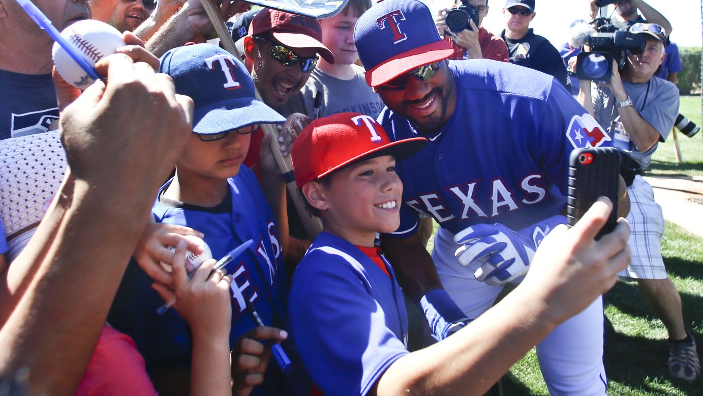 Seattle Seahawks quarterback Russell Wilson -- taking part in spring-training exercises with the Texas Rangers -- poses with a young fan Saturday, March 28, in Surprise, Arizona. The football star played baseball in college and was actually drafted by the Colorado Rockies in 2010. He even spent some time in the minor leagues before concentrating on his football career.
