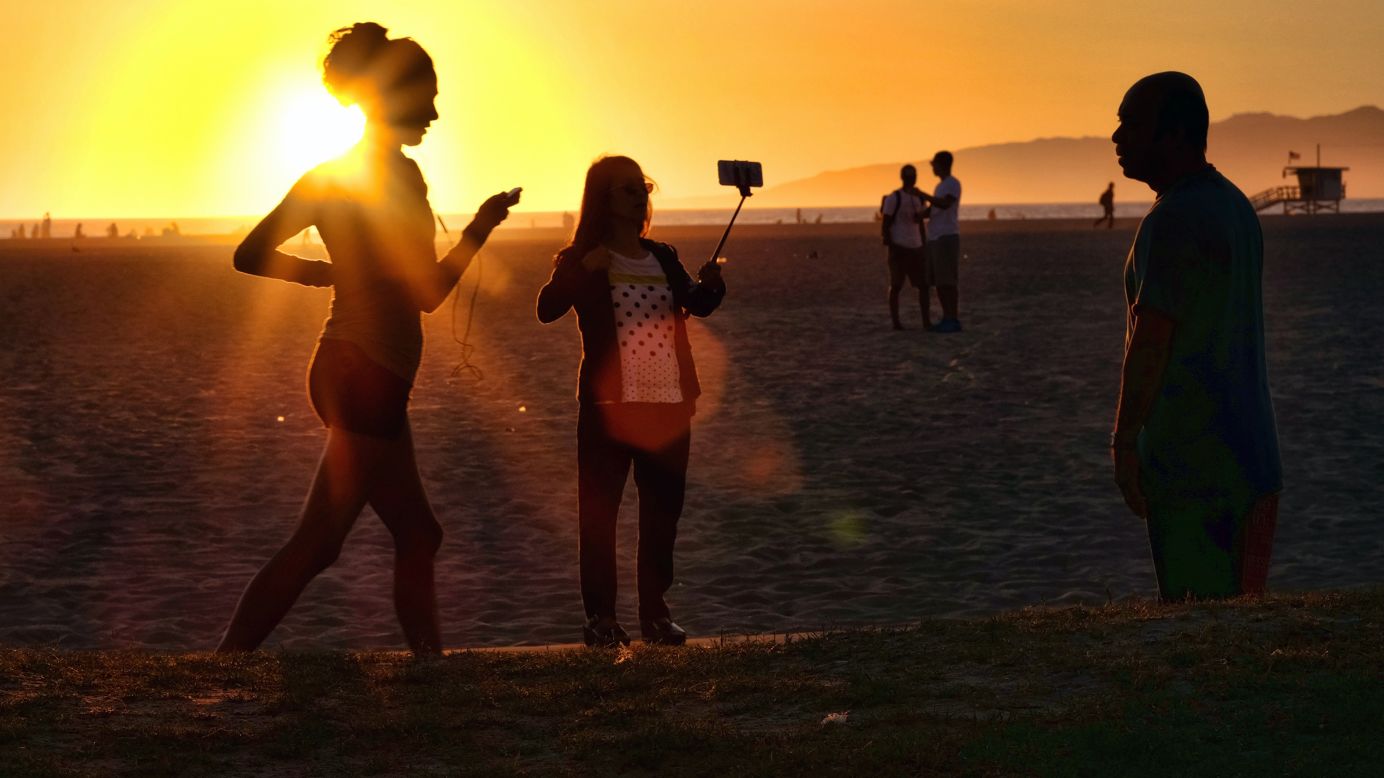 A beachgoer uses a selfie stick as the sun sets in Los Angeles on Friday. March 27. <a href="http://www.cnn.com/2015/03/25/living/gallery/look-at-me-selfies-0325/index.html" target="_blank">See 33 selfies from last week</a>