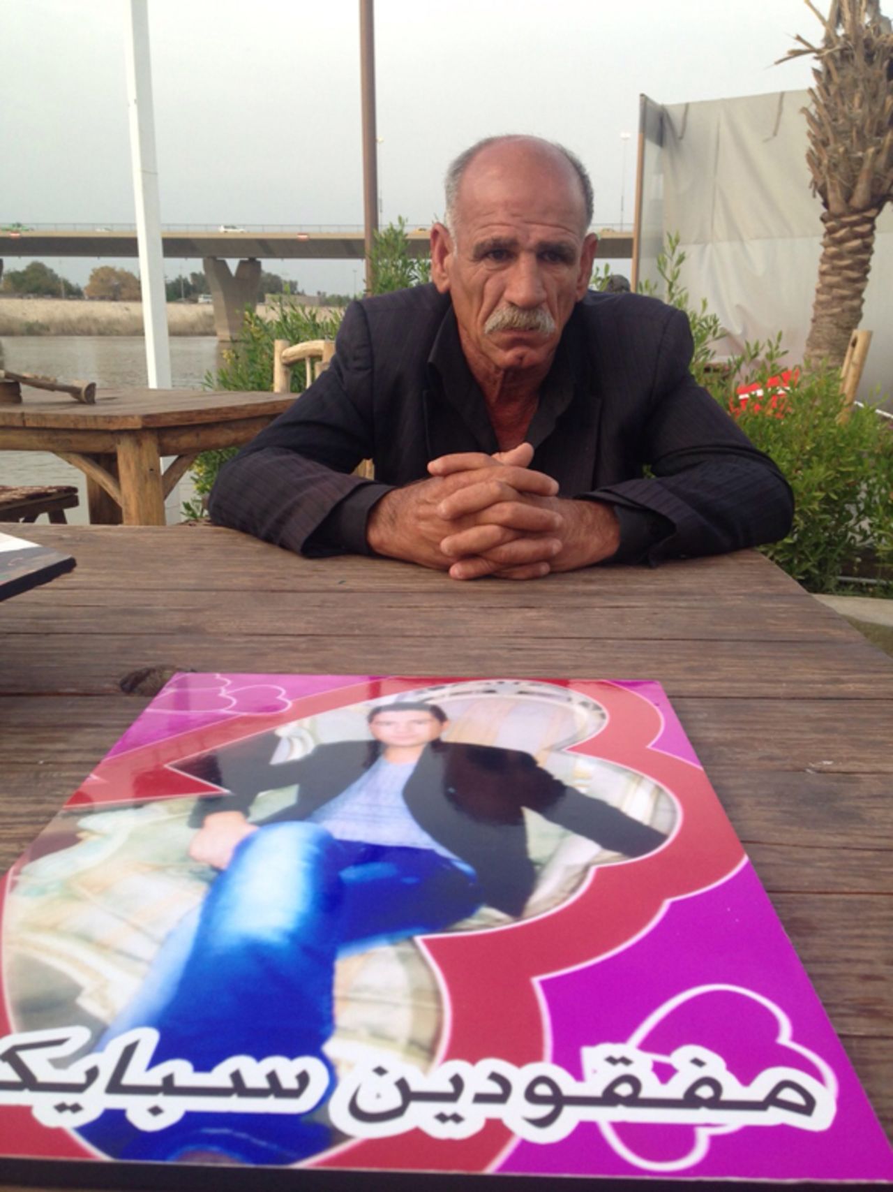 Majed al-Jubouri quit his job last year and spends his days searching for his 21-year-old son, Imad, pictured in the photo in front of him. Imad joined the military last June. A caption on the photo reads: "Speicher missing."