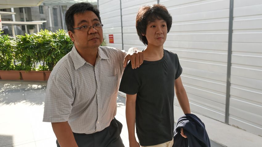 Amos Yee, a 16-year-old student, arrives with his father at the State courts in Singapore on Tuesday after being charged for making a YouTube video highly critical of late founding leader Lee Kuan Yew.
