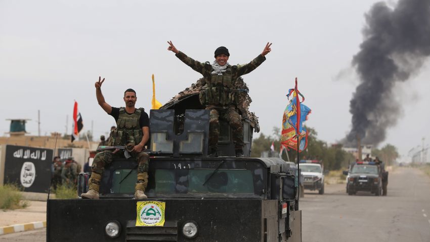 Iraqi security forces celebrate as they a street in Tikrit, on April 1, 2015, a day after the prime minister declared victory in the weeks-long battle to retake the city from the Islamic State (IS) group. Iraqi forces battled the last jihadists in the northern city on April 1, 2015 to seal a victory the government described as a milestone in efforts to rid the country of the Islamic State group. AFP PHOTO / AHMAD AL-RUBAYE        (Photo credit should read AHMAD AL-RUBAYE/AFP/Getty Images)