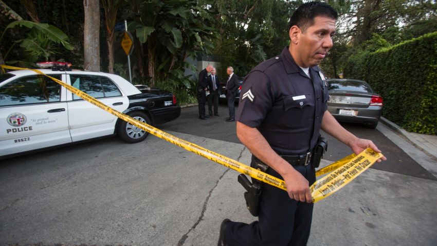 A police officer creates a perimeter outside a home in the Hollywood Hills area of Los Angeles, Tuesday, March 31, 2015. Police say a man was found dead at the home of Andrew Getty, heir to Getty oil fortune. (AP Photo/Ringo H.W. Chiu)