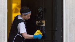 A cleaner polishes the door of number 10 Downing Street in London on March 30, 2015.