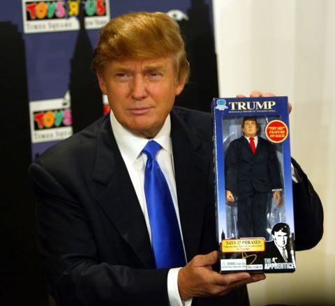 Trump poses with the new Donald Trump 12-inch talking doll on September 29, 2004, at the Toys 'R' Us store in New York City.