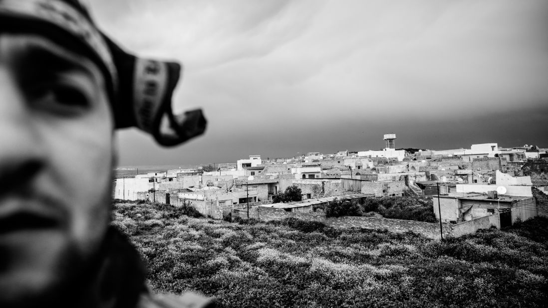 A militia member on the rooftop of a local house in Baqufa that serves as a base. Fighters are a mixed bunch -- including an electrician, a baker and his father. 