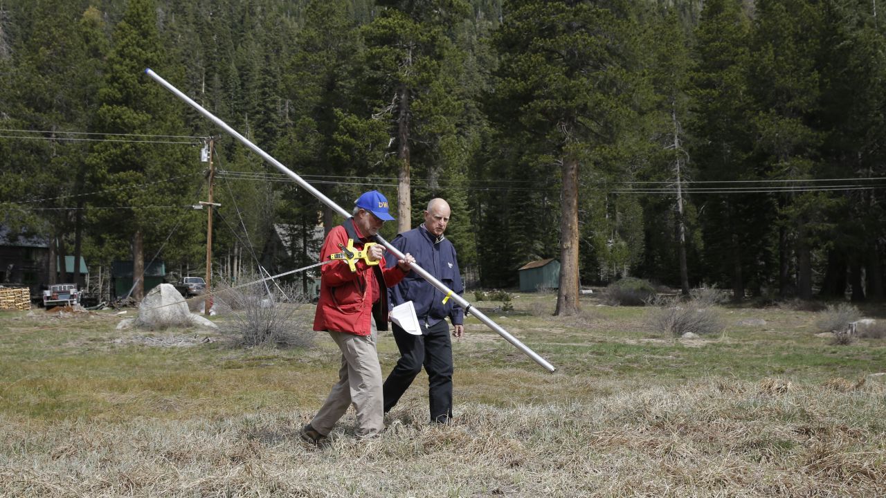 California Gov. Jerry Brown, right, walks with Frank Gehrke, chief of the California Cooperative Snow Surveys Program for the Department of Water Resources, near Echo Summit, California, in April. Gehrke said this was the first time since he has been conducting the survey that he found no snow at that location at that time of the year.