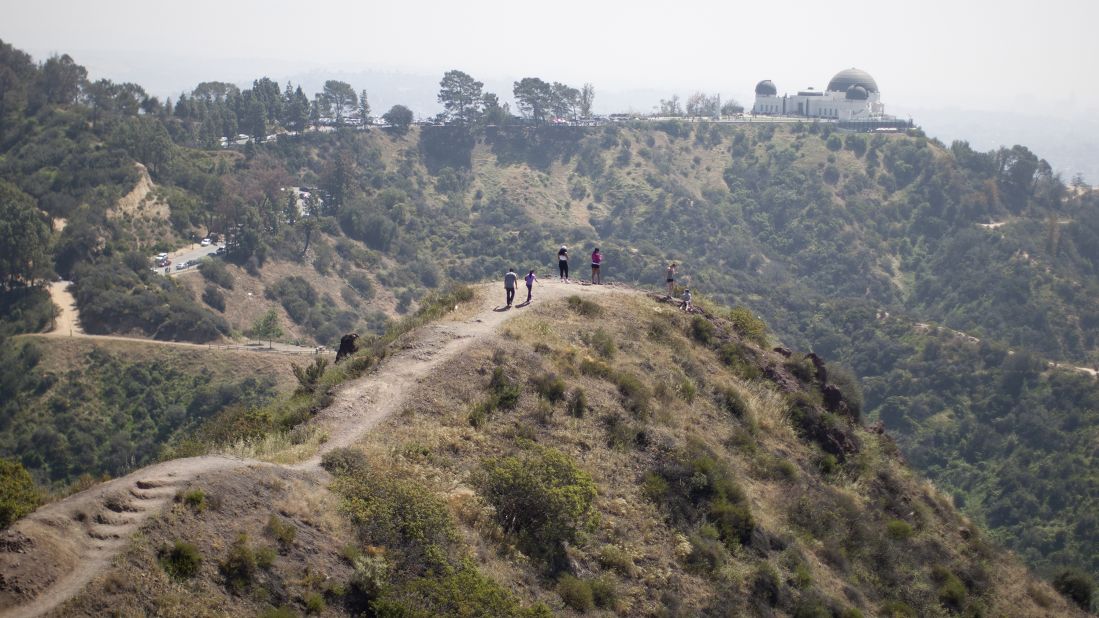 People hike along a ridge overlooking the Griffith Observatory, where vegetation was  drying out in Los Angeles in March 2015.