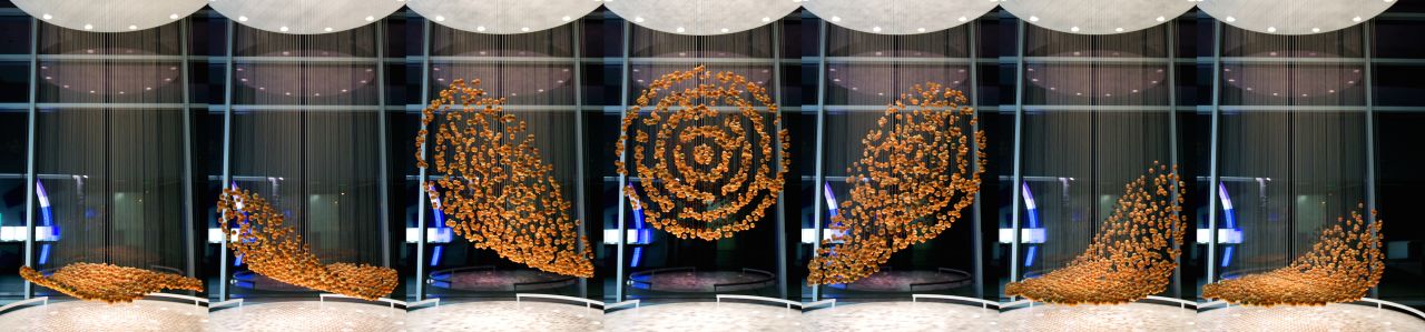 The 804 suspended wooden spheres <a href="http://www.hypersonic.cc/projects/breakingwave" target="_blank" target="_blank">move independently on several miles of wire rope</a>, and the ordered pattern will only become clear from the chaos to the viewer who looks at them from exactly the right perspective.