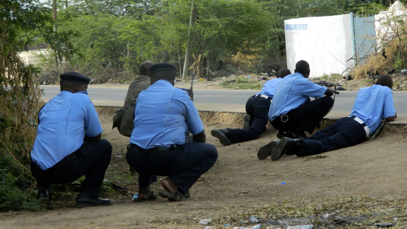 Kenyan police take cover outside the school during the attack.