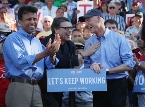 Jindal and Texas Gov. Rick Perry (center) campaign with Florida Gov. Rick Scott on November 3, 2014, in The Villages, Florida.