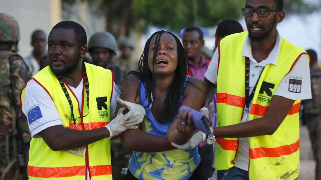 A woman is helped away from the building where she had been held hostage at the school.