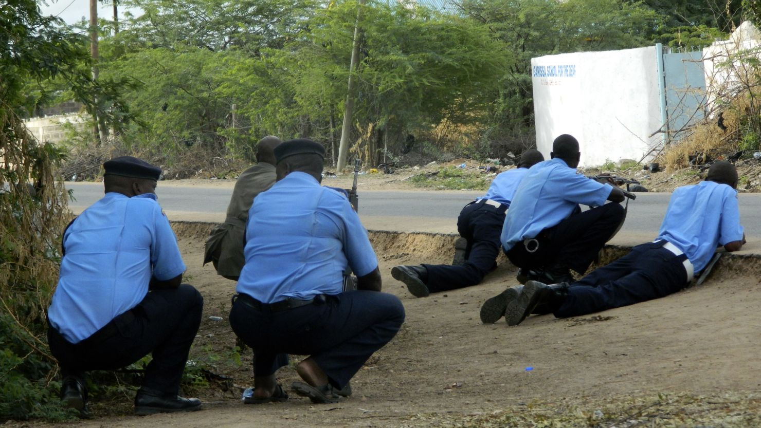 Kenyan police officers take cover outside Garissa University College on Thursday.
