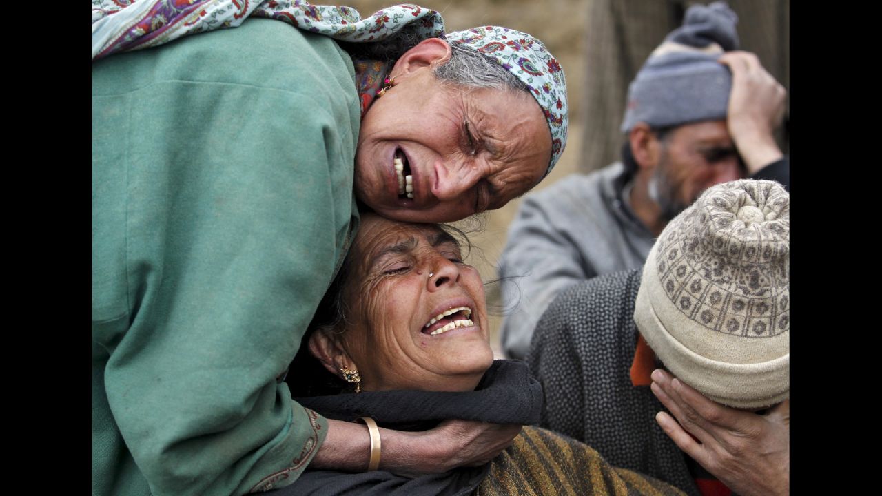 Relatives mourn together Tuesday, March 31, during a funeral for landslide victims in India-controlled Kashmir. With unseasonal rains raising fears of flash floods in the region, Indian authorities have been rescuing stranded villagers.