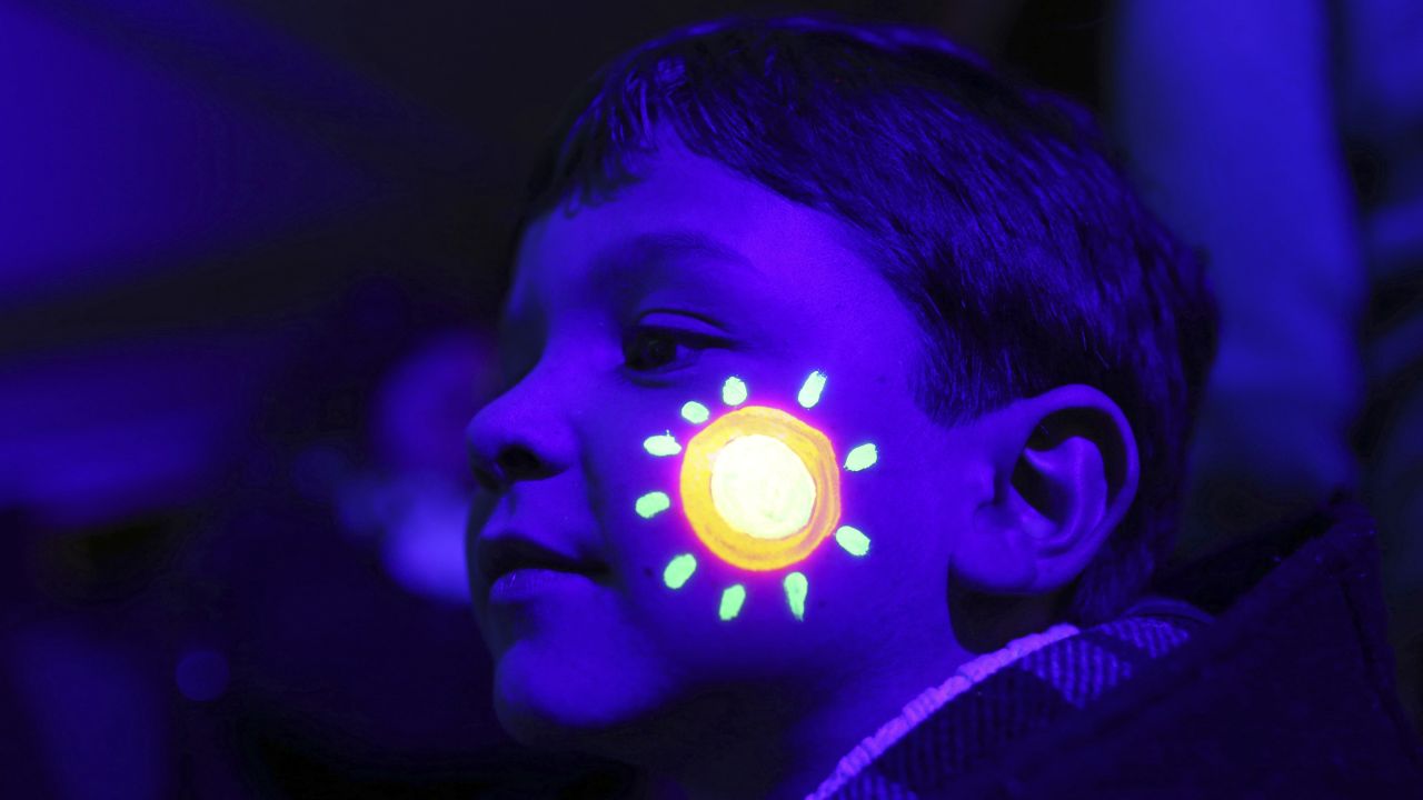 A boy in Lisbon, Portugal, has luminous ink on his face for Earth Hour, a symbolic switching-off of lights on Saturday, March 28. At 8:30 p.m. local time, people around the world turned off their lights for one hour to build awareness about energy use and climate change.
