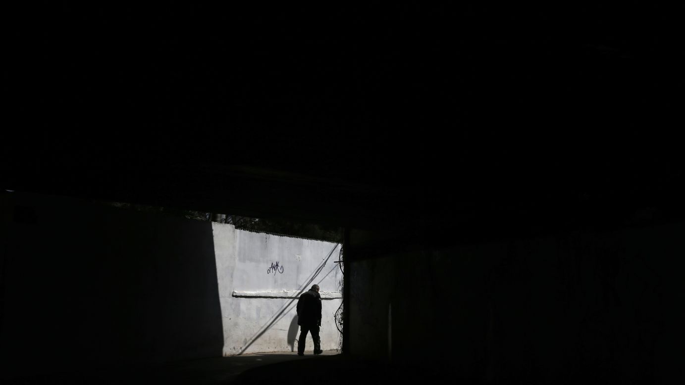 A man walks under a bridge in Athens, Greece, on Monday, March 30. Greece and its international creditors are still struggling to agree on a list of economic reforms that are deemed necessary for the country to unlock emergency funds and stay afloat.