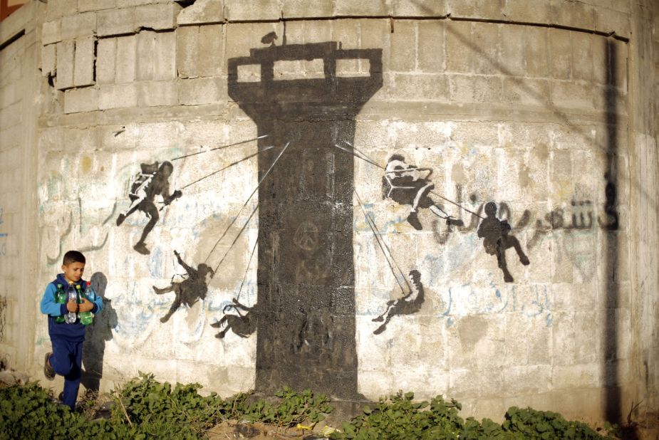 In February 2015, the secretive street artist was in Beit Hanoun, Gaza. His mural, here, depicts children using an Israeli army watchtower as a swing ride.