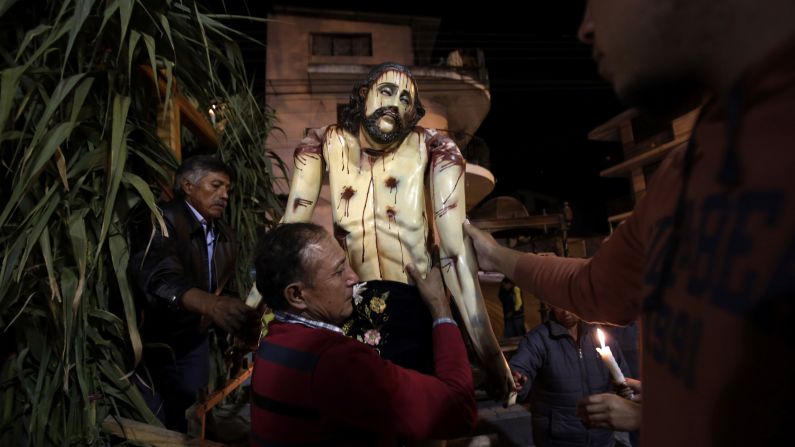 A man carries away a sculpture of Jesus after it was paraded at a nighttime Holy Week procession in Puellaro, Ecuador, on Tuesday, March 31. The procession, called "Procesion de Andas," is an annual tradition. Those who carry the heavy sculptures on large platforms inherit the responsibility from their parents or a friend and consider it an honor. 