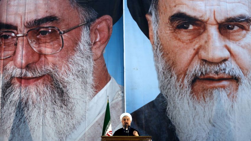 Iranian President Hassan Rouhani delivers a speech under portraits of Iran's supreme leader, Ayatollah Ali Khamenei (L) and Iran's founder of the Islamic Republic, Ayatollah Ruhollah Khomeini (R), on the eve of the 25th anniversary of the Islamic revolutionary leader Ayatollah Ruhollah Khomeini's death, at his mausoleum in a suburb of Tehran on June 3, 2014. AFP PHOTO / ATTA KENARE (Photo credit should read ATTA KENARE/AFP/Getty Images)