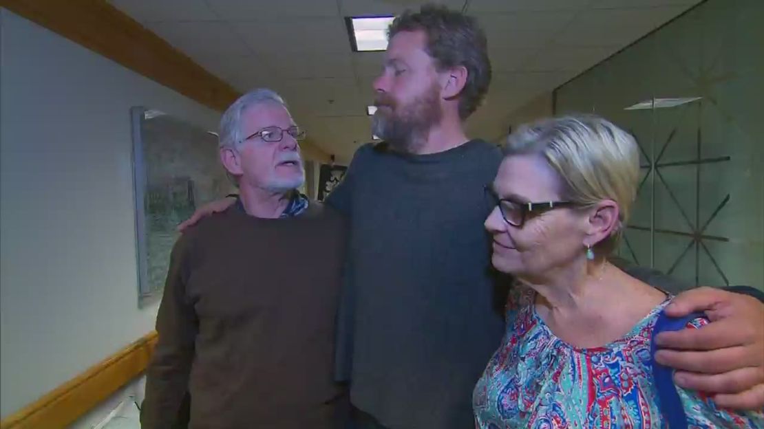 Louis Jordan, center, stands with his parents after what he says were 66 days drifting alone in the Atlantic Ocean.