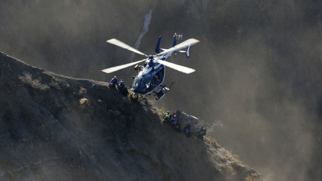 A helicopter drops rescue workers next to crash debris near Seyne-les-Alpes, France, on Sunday, March 29.