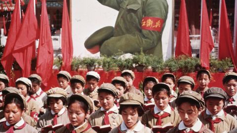 A group of Chinese children in uniform hold Mao's 'Little Red Book' during China's Cultural Revolution. 