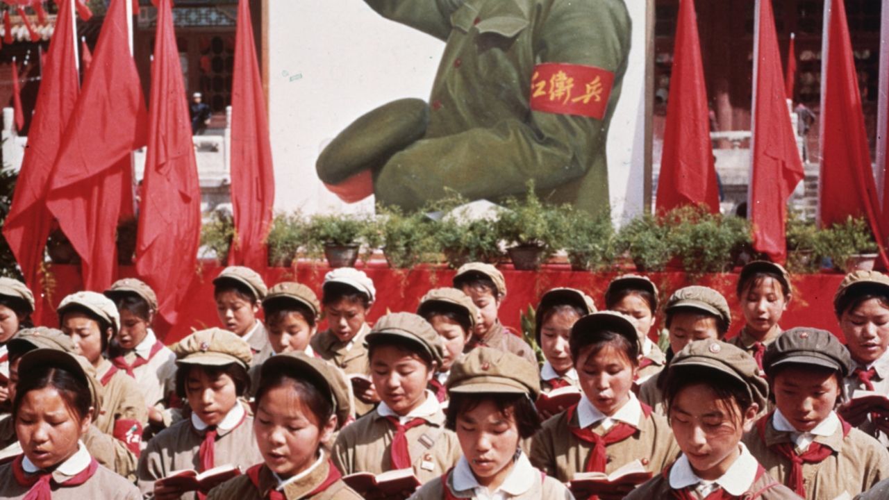 A group of Chinese children in uniform hold Mao's 'Little Red Book' during China's Cultural Revolution.
