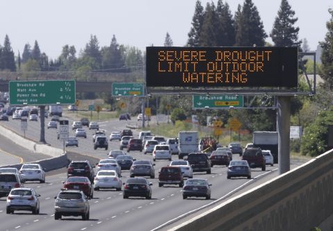 Motorists in Rancho Cordova, California, pass a sign in April reminding them to reduce water use.
