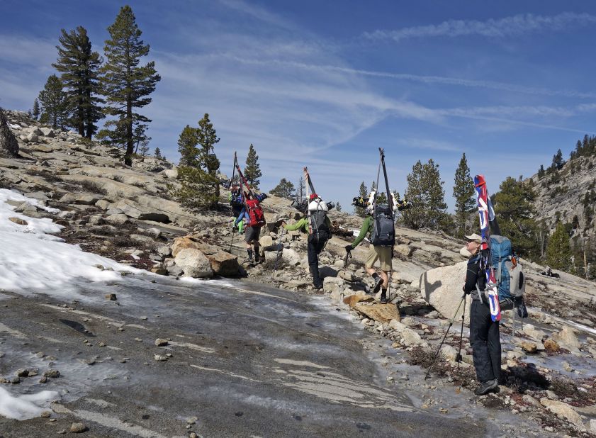 A woman in Sequoia National Park looks up at barren terrain typically populated by skiers in April.