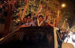 People stand in the sunroof of a car and flash the 'V for Victory' sign as they celebrate on Valiasr street in northern Tehran on April 2, 2015, after the announcement of an agreement on Iran nuclear talks. Iran and global powers sealed a deal on April 2 on plans to curb Tehran's chances for getting a nuclear bomb, laying the ground for a new relationship between the Islamic republic and the West.