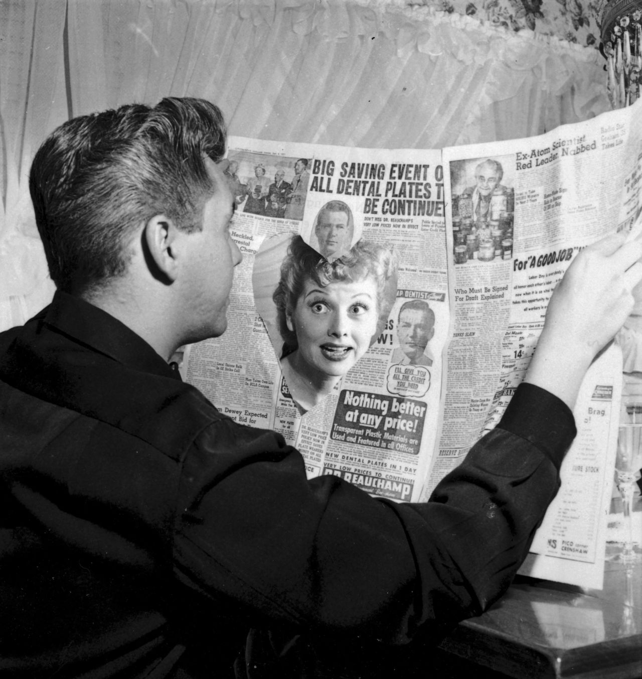 Ball looks at Arnaz through a heart cut out in a newspaper. The couple married in 1940 and divorced 20 years later.